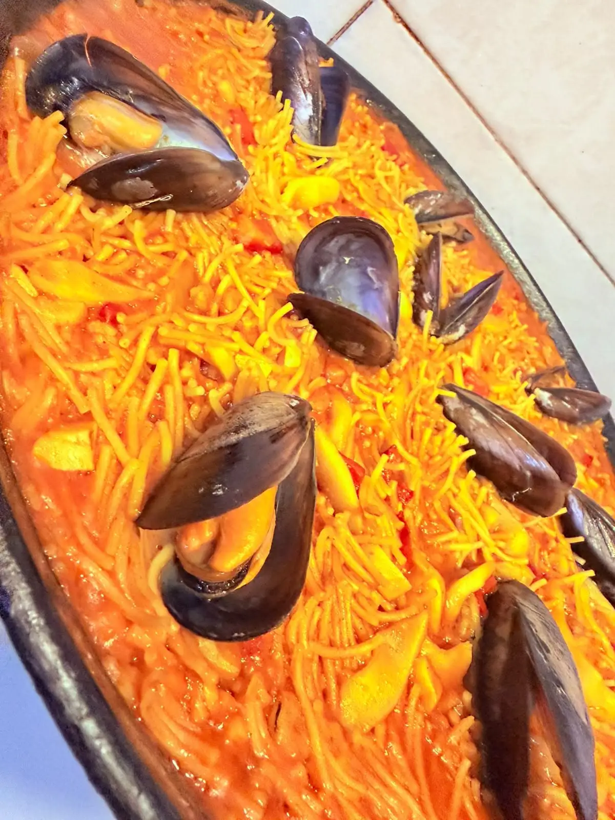 Fideuá with mussels, served in the pan.